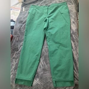 Green tailored pants with hem detail.